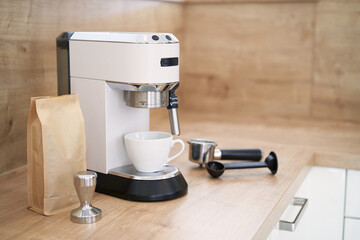 Kaffeemaschine mit Tasse und Utensilien in einer Holzküche
