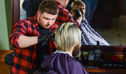 brutal bearded man at hairdresser salon with master, hair look