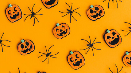 Halloween banner flat lay. Modern pumpkins jack o lantern and spiders layout on orange background. Happy Halloween. Halloween decorations pattern on yellow paper. Halloween background