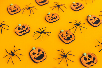 Happy Halloween. Pumpkins jack o lantern and spiders on orange background. Halloween decorations layout on yellow paper. Halloween background. Festive pattern