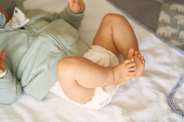 nackige Baby Füße mit weißer Windel, beim Strampeln