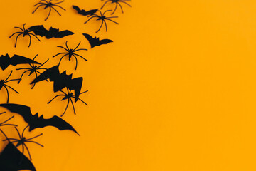 Happy Halloween. Spiders and bats layout on orange background with space for text. Season's...