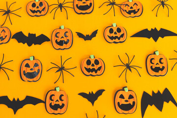 Halloween flat lay. Modern pumpkins jack o lantern, spiders, bats layout on orange background....