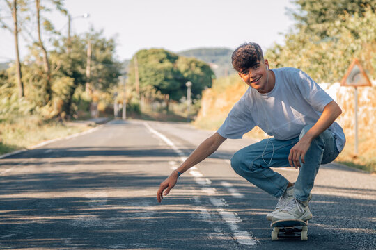 teenage boy with skateboard on the road
