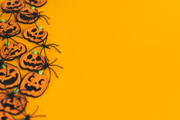 Halloween border. Modern pumpkins jack o lantern and spiders on orange background with space for...