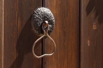 Antique metal door handle on a rough wooden background. Close-up. Vintage Door Handle