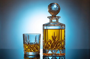 Cognac or brandy on a glossy table on an isolated blue background