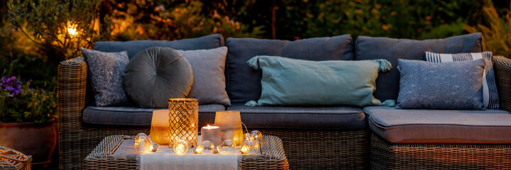Warm summer night in the garden with trendy furniture, lights, l
