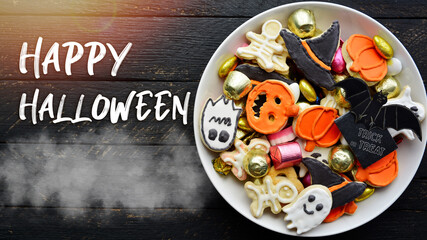 holiday Halloween candy bowl of cookies, candy, chocolates and sweets, Halloween Jack o Lantern - Trick or Treat Halloween card dark background