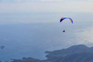 Paragliders flying from a top of Tahtali mountain near Kemer, Antalya Province in Turkey. Concept of active lifestyle and extreme sport adventure