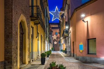 Fototapeta na wymiar Old city street and Christmas illumination in Alba, Italy.