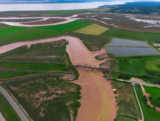 Train trestle crossing a muddy river
