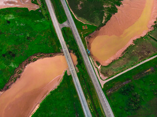Aerial looking down at the highway crossing a muddy river