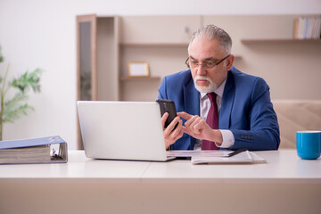 Old male employee working from home during pandemic