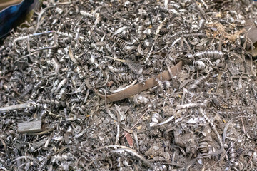 Metal shavings and other waste in a trash bin in a metalworking workshop.