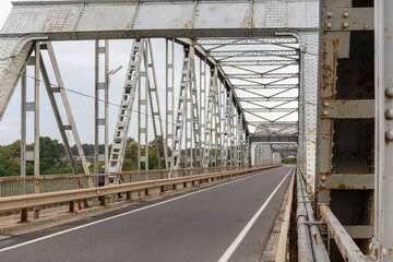 road across the metal bridge with trusses