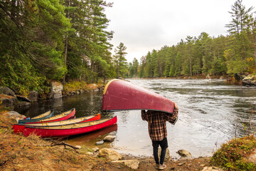 A canoe being portaged to a put in a on the Madawaska River on a fall day in Eastern Ontario, Canada.
