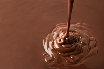 Chocolate splash falling on liquid chocolate background