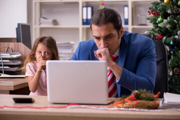 Young male employee celebrating Christmas at workplace with his