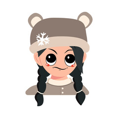 Girl with emotions of suspicious, displeased eyes and black hair in bear hat with snowflake. Cute child with annoyed expression in winter headdress. Head of adorable kid with emotions