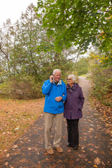 A Senior couple spends a fall day outdoors walking, relaxing and working in the garden.