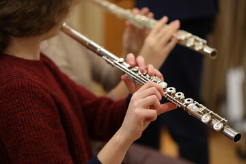 Girl playing the flute hand close up
