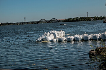 Construction of the foundation for a pier on the river. Big Bags with heavy stones are laid out on...