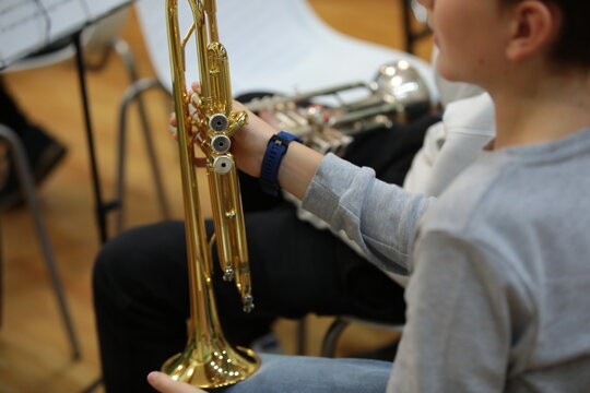 Golden trumpet in the hand of a musician trumpeter.School jazz band rehearsal background image selective focus on equipment