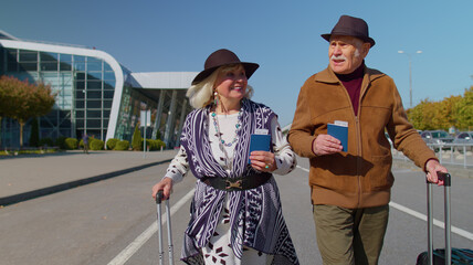 Senior couple happy pensioner tourists grandmother grandfather stay with luggage suitcases,...