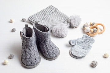Collection of cute organic  baby clothes and booties. Warm hat, mittens and boots for cold weather of fall and winter season. Newborn gifts for Christmas and baby shower, donation idea.