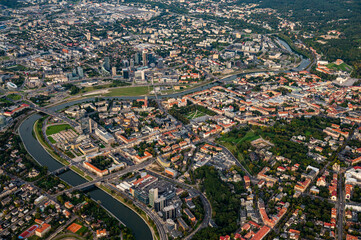 Fototapeta na wymiar Scenic view on central part of Vilnius capital of Lithuania from hot air balloon. Neris river flowing curve through the city. Downtown district view from the sky