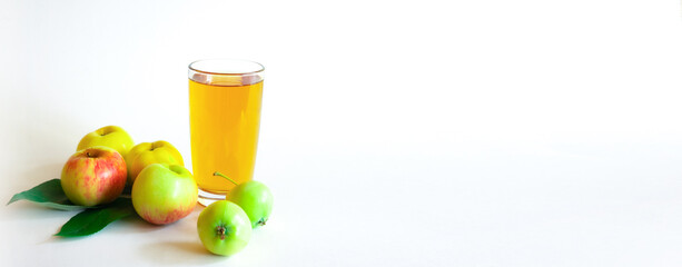A cup of apple juice and apples on the white background 
