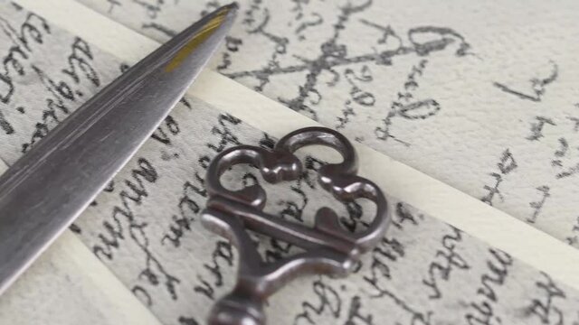 Close-up of accessories on vintage handwriting. Vintage keys, wooden stampers, sealing wax, paper knife, metal nibs and old pen. Vintage stationery. Flat lay