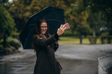 Beautiful young woman taking selfie with her smartphone