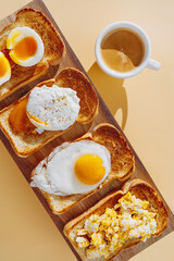 fried Toast bread with four different types of cooked chicken eggs, scrambled eggs, fried eggs, poached egg and creamed egg. Breakfast of chicken eggs.