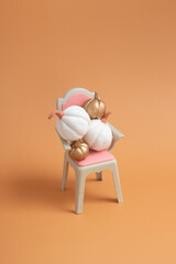 Autumn creative still life of white and gold pumpkins on the chair