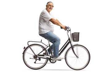 Fototapeta premium Smiling mature man in jeans and white t-shirt riding a bicycle