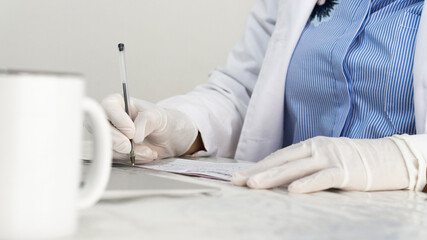 Unrecognizable doctor writing a prescription.