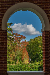 An Autumn  forest view  through a brick arch