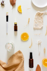 Healthcare spa concept. Mock up with dried leaves, orange, cotton bag, bottles and bath salts on white background. Flat lay, top view. Beauty, lifestyle, skin care, composition.