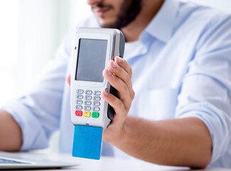 Man processing credit card transaction with POS terminal