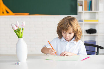 School boy with writing lesson. Kids in classroom at school.