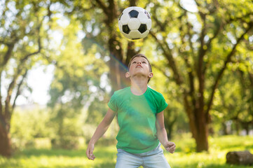 Attentive boy looking at soccer ball up in air