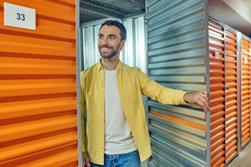 Cheerful man standing near garage door