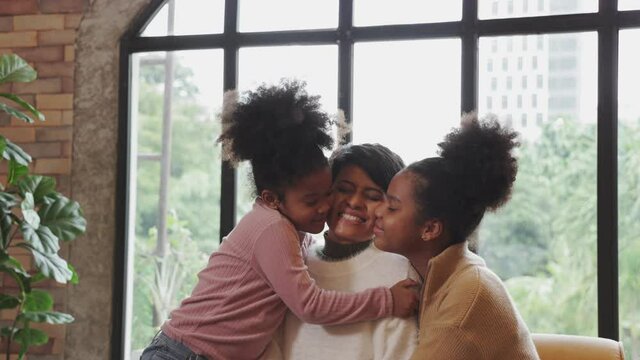Two African American girls kissed their mother on Mother Day.