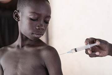 Small black African boy receiving first intramuscular malaria vaccine dose