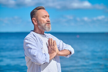 Calm man in namaste pose outdoors