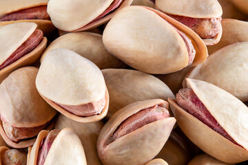 Macro shot of unshelled pile of pistachios on isolated white background.