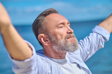 Serious man in harmonious mood outdoors