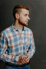 portrait of a young bearded man in shirt gray background